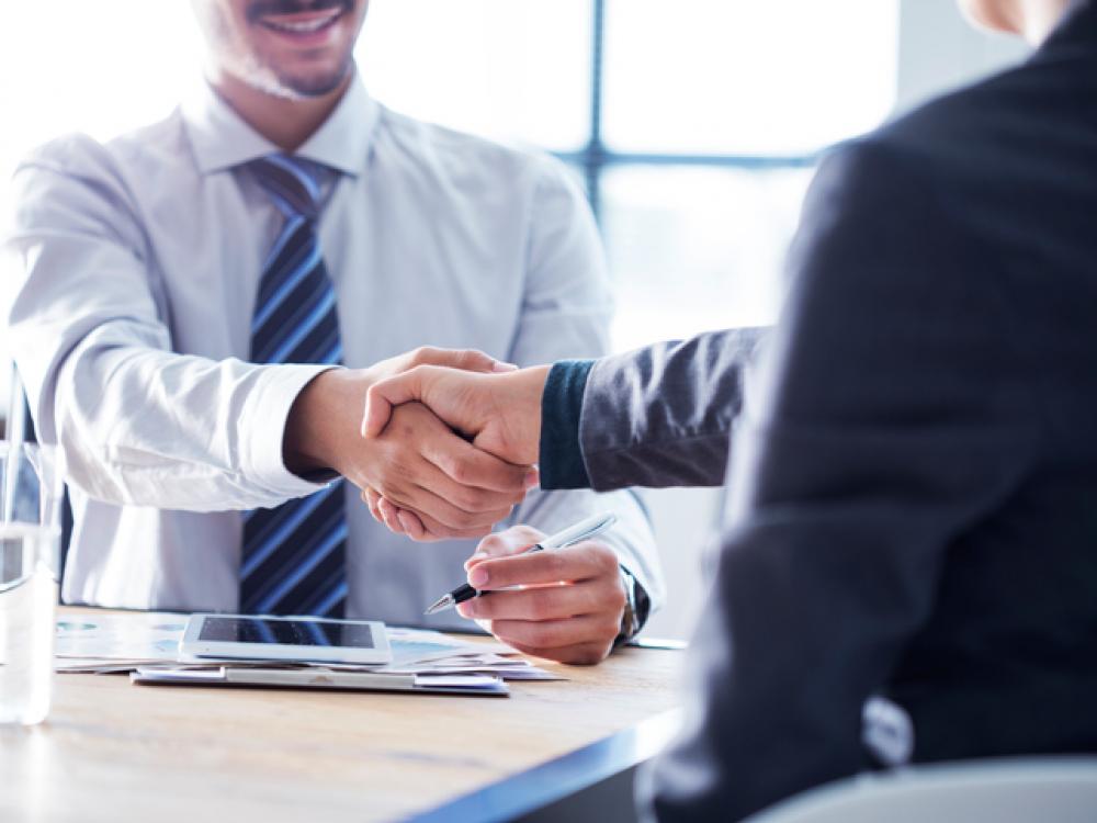Business professionals shaking hands in a modern office building